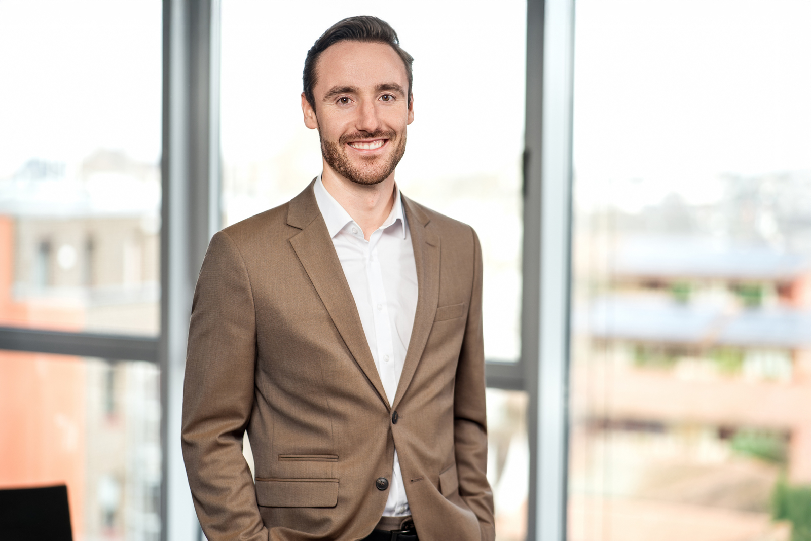 Berater im braunen Sakko am Fenster – Ernst & Young Köln